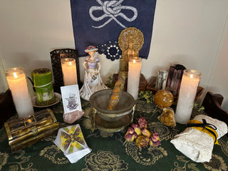 Beltane altar table with green cloth scarf candles dried flowers crystals the awakening tarot card deck smoke cleansing wand smudge bundle